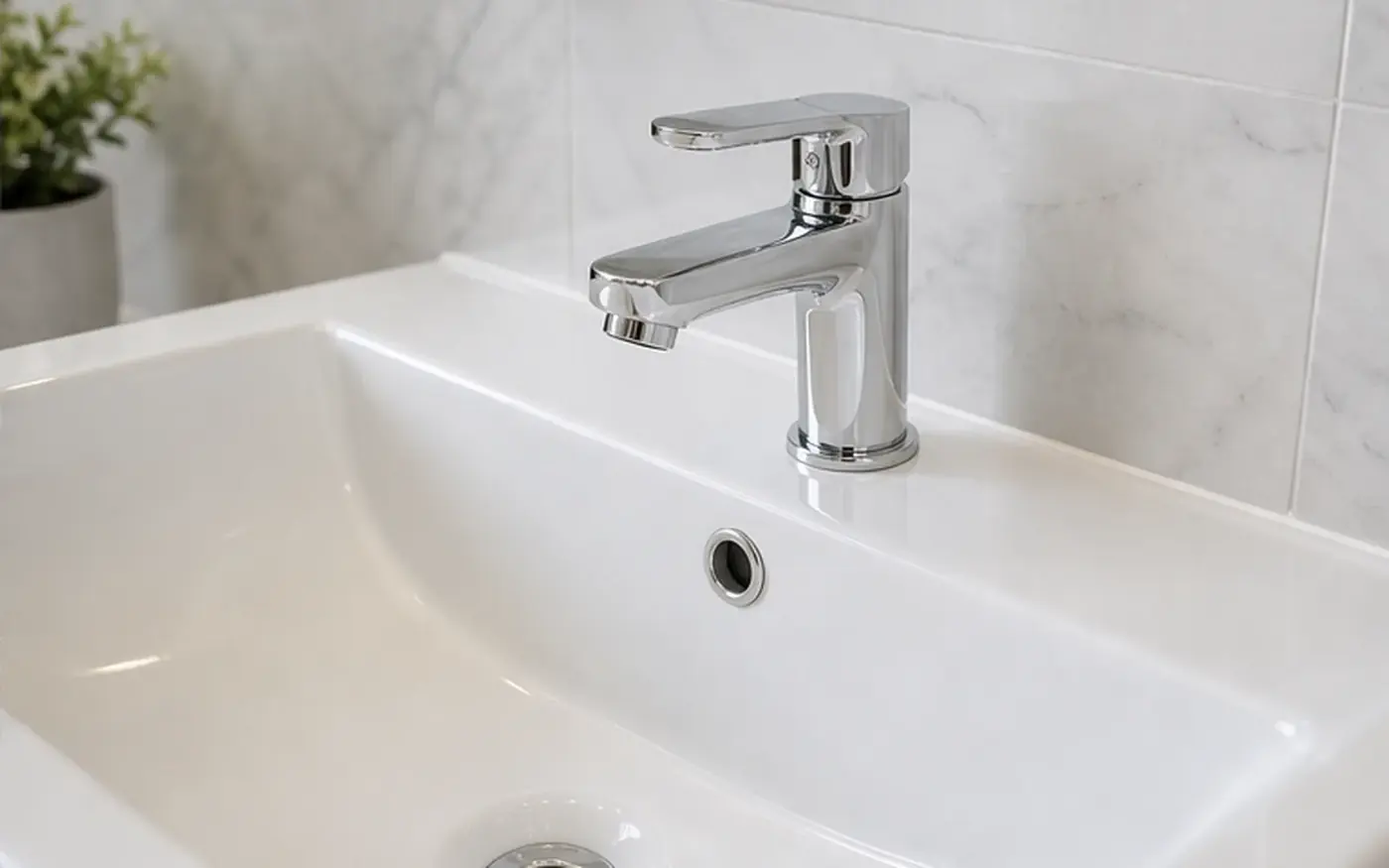 Clean white bathroom basin with a chrome tap