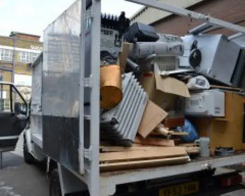 Household furniture and discarded items loaded into a van