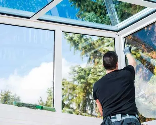 Worker cleaning the outside of a window frame