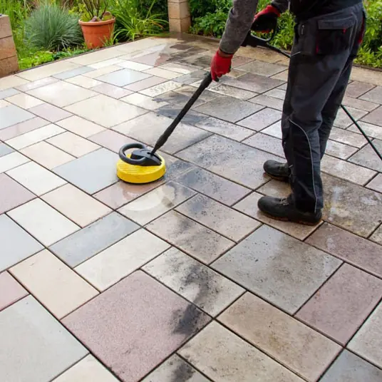 Pressure washer cleaning stone patio slabs