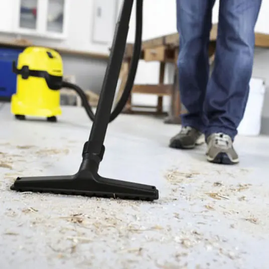 Vacuum nozzle collecting construction dust from a floor
