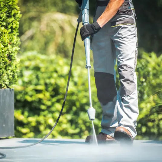 Pressure washer removing dirt from outdoor paving